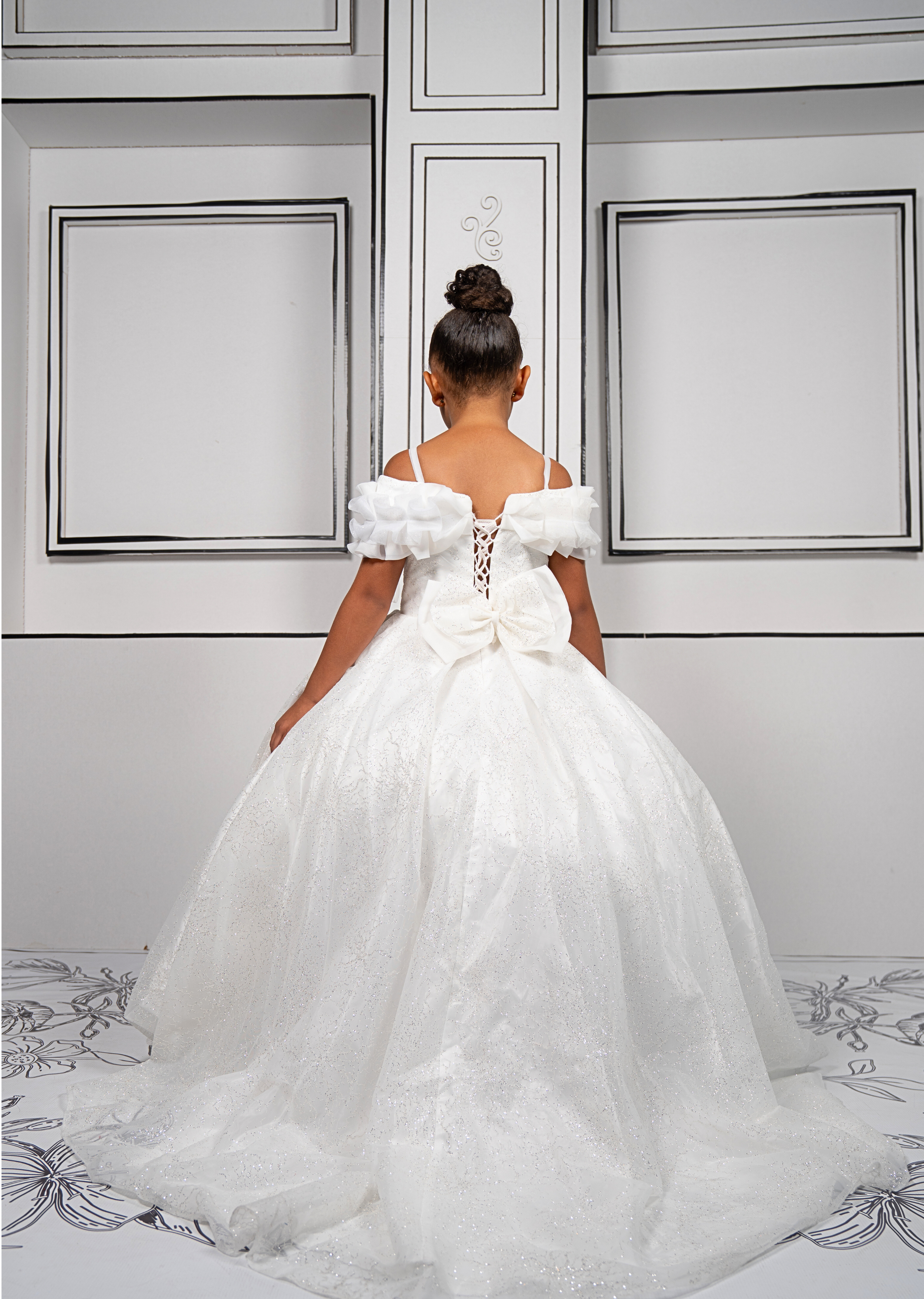 This elegant white ball gown is perfect for flower girls and little brides. With sparkly tulle and a dreamy silhouette, it’s a fairytale favorite.